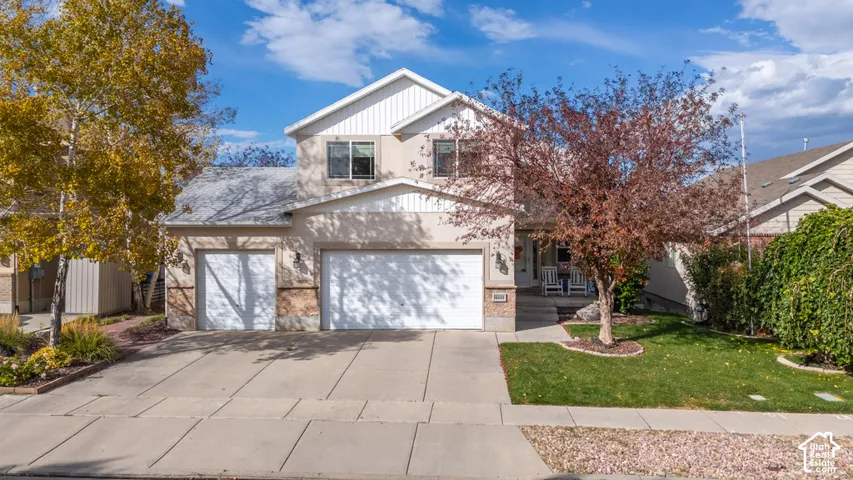 Contemporary residence featuring a two-car garage, stone and stucco facade, and a covered porch entry