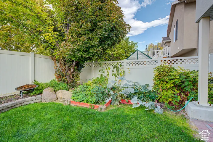 Manicured lawn with a raised garden bed and stone landscaping elements