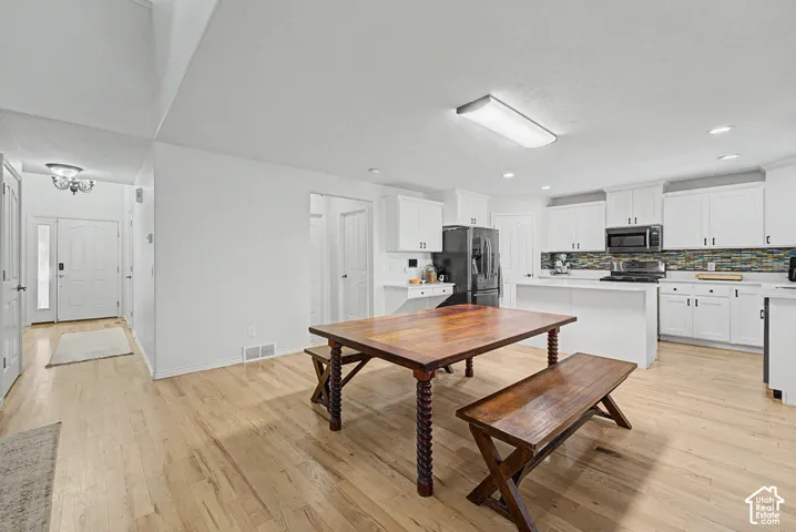 Spacious interior featuring wood-finish flooring, white walls, and a recessed lighting