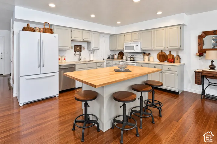 Kitchen featuring shaker-style cabinetry, a central island with a wood-finish countertop, recessed lighting, and wood-finish flooring