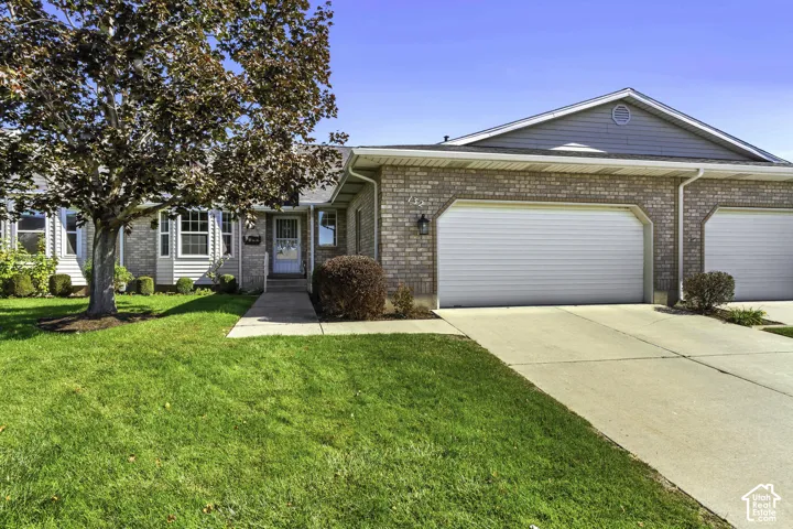 Brick and horizontal siding exterior featuring a multi-car garage, concrete driveway, and covered front entry