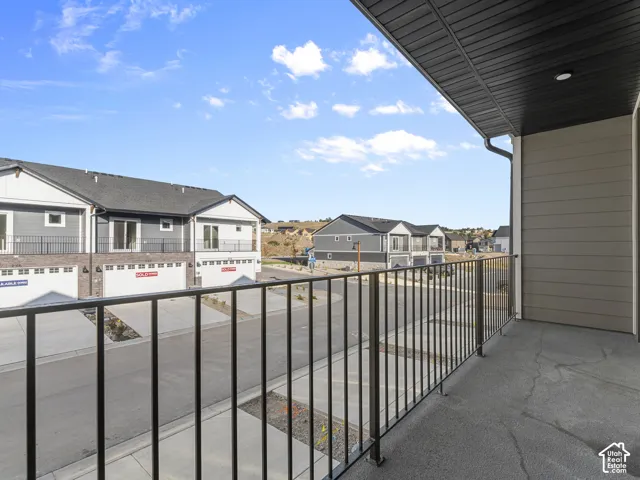 Covered balcony featuring concrete flooring, black metal railing, and recessed ceiling lighting