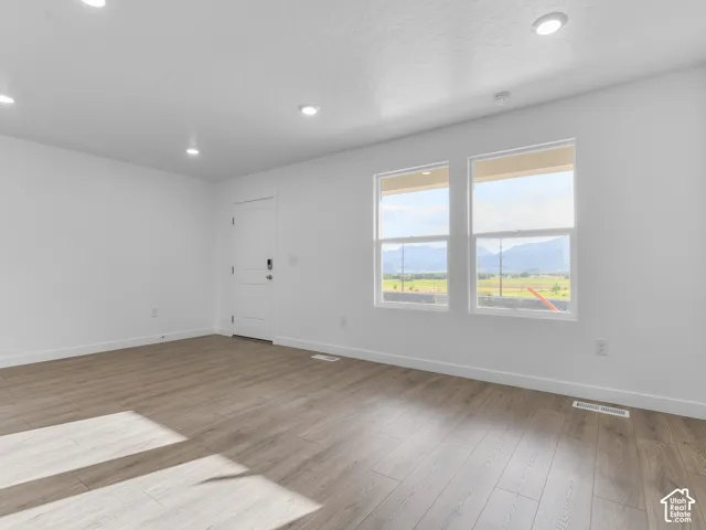 Interior room featuring wood-finish flooring, recessed lighting, and dual windows providing mountain scenery