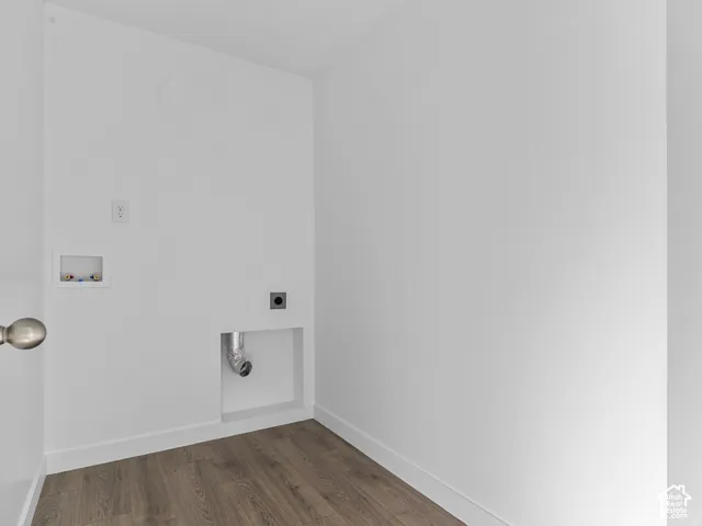 Utility space featuring wood-finish flooring, recessed dryer venting, and a dedicated recessed water supply box
