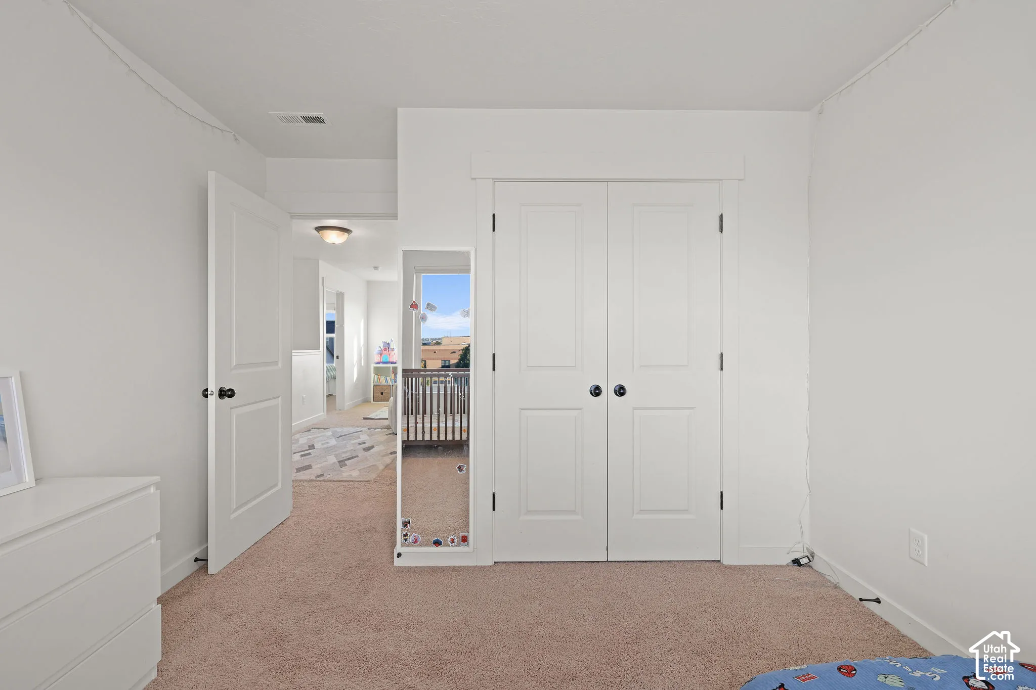 Room featuring neutral-toned carpeting, dual-panel interior doors, and white-painted millwork