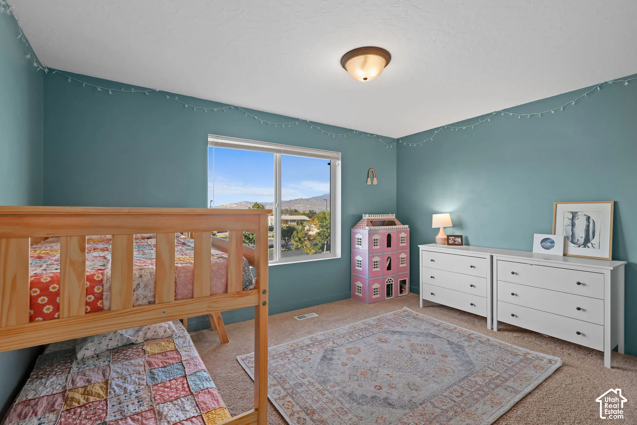 Neutral-toned wall-to-wall carpeting, dual-pane window with mountain scenery, and flush-mount ceiling lighting