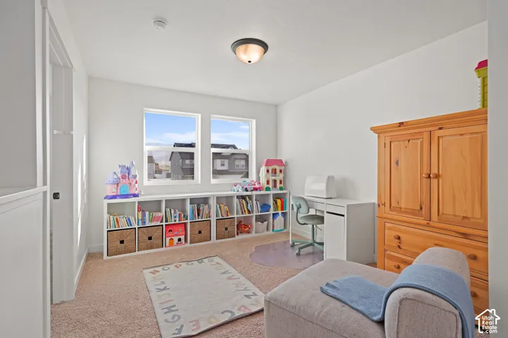 Neutral-toned room featuring wall-to-wall carpeting, dual windows with white casing, and a flush-mount ceiling light fixture
