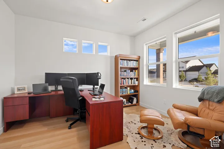 Neutral-toned walls, wood-finish flooring, and expansive windows featuring architectural transom windows above