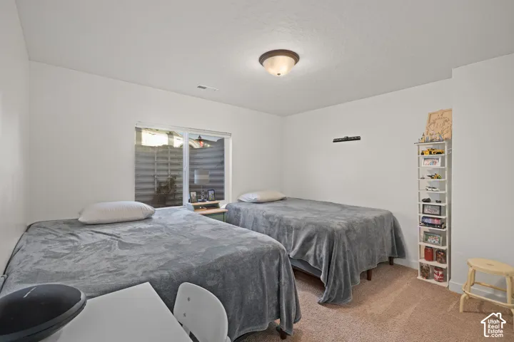 Room featuring neutral wall finishes, plush carpeting, a single-pane window with a horizontal blind, and a flush-mount ceiling fixture