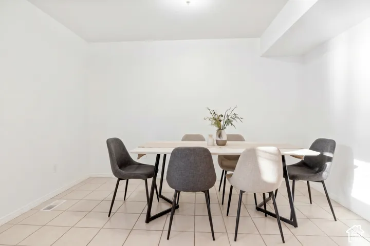 Neutral interior space featuring high-contrast white walls, ceramic tile flooring, and a ceiling-mounted light fixture