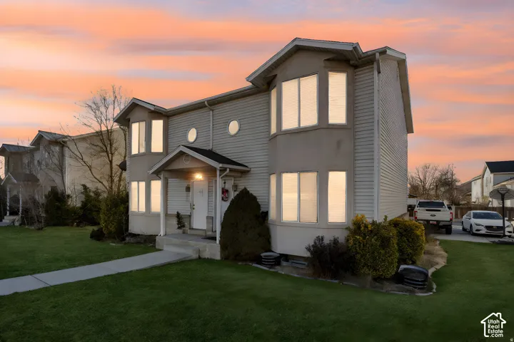Two-story exterior featuring dual bay windows, circular accent windows, and a covered front entry