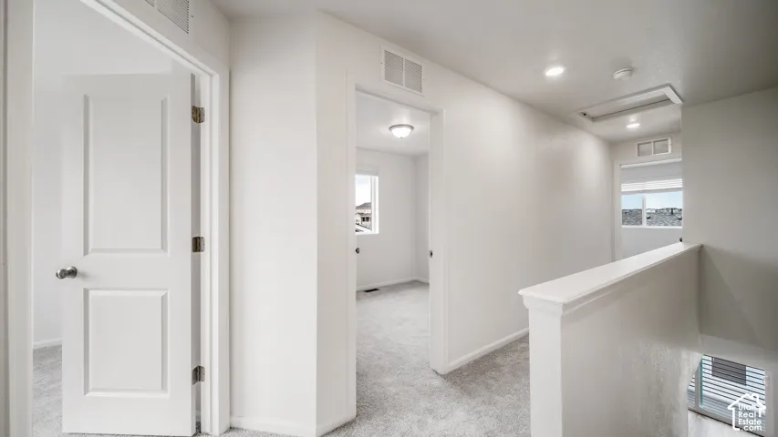 Neutral-toned carpeting, recessed ceiling lighting, and solid-core paneled interior doors
