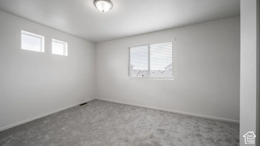 Neutral-toned carpeting, dual-pane windows, and high-set transom windows providing natural light
