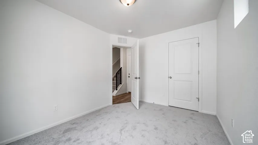 Neutral-toned carpeting, two-panel interior doors, and recessed ceiling lighting