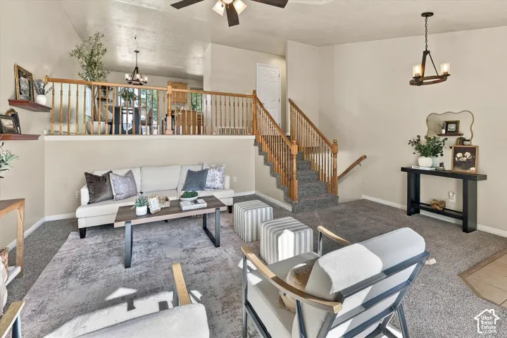 Split-level interior featuring a carpeted staircase with wood balusters, recessed wooden railing, neutral wall finishes, and elevated wall-mounted shelving