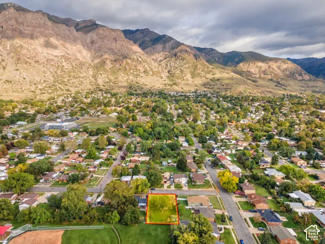 Property Lines are approximate. Buyer to verify all. Aerial perspective of a residential lot featuring mature trees and a prominent mountain backdrop