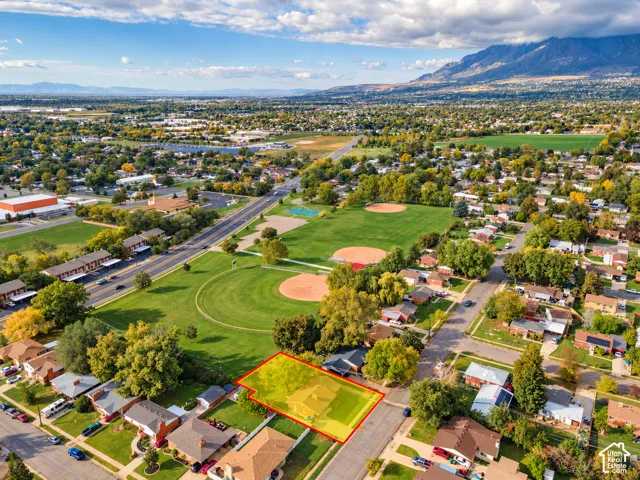 Property Lines are approximate. Buyer to verify all.Aerial view of residential lot featuring mature trees, a rectangular parcel boundary, and a backdrop of mountain peaks