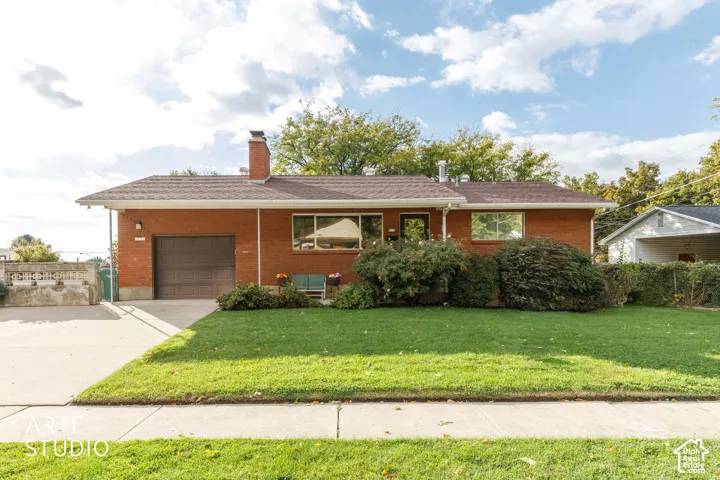 Brick exterior facade featuring a shingled roof, an attached single-car garage, an exterior brick chimney, and a concrete driveway