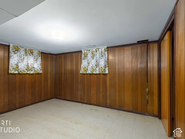 Wood paneling, tile flooring, and two windows