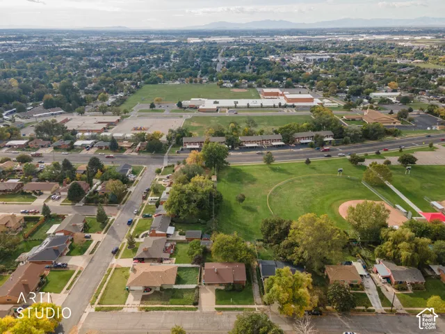 Aerial perspective featuring residential lots situated near expansive green space, mature canopy trees, and established neighborhood infrastructure