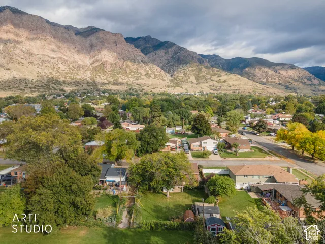 Aerial perspective featuring mountain range scenery and established residential surroundings with mature tree canopy