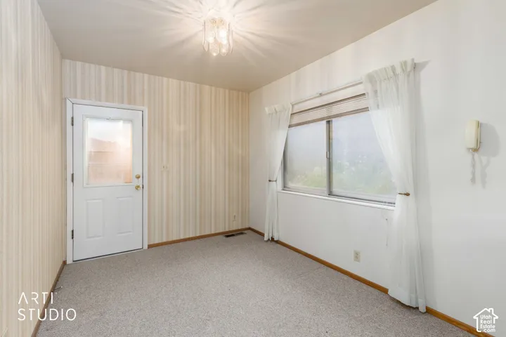 Textured wallpaper, carpeted flooring, multi-pane window with horizontal blinds, and a semi-flush mount ceiling fixture