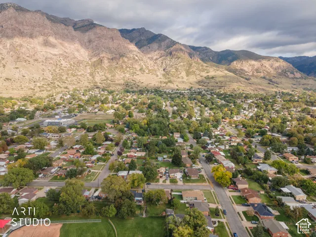 Aerial perspective featuring mountain topography, mature trees, and established grid-patterned streets