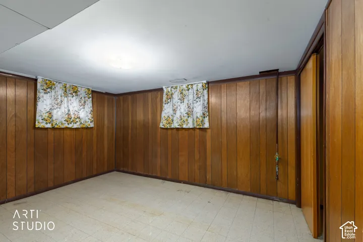 Wood paneling, tile flooring, and two windows