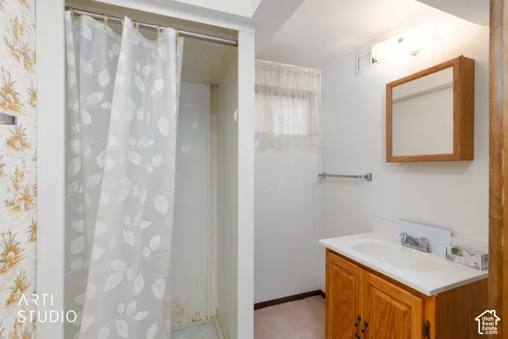 Bathroom featuring a wood-finish vanity with an integrated basin, wall-mounted wooden medicine cabinet, and a walk-in shower stall