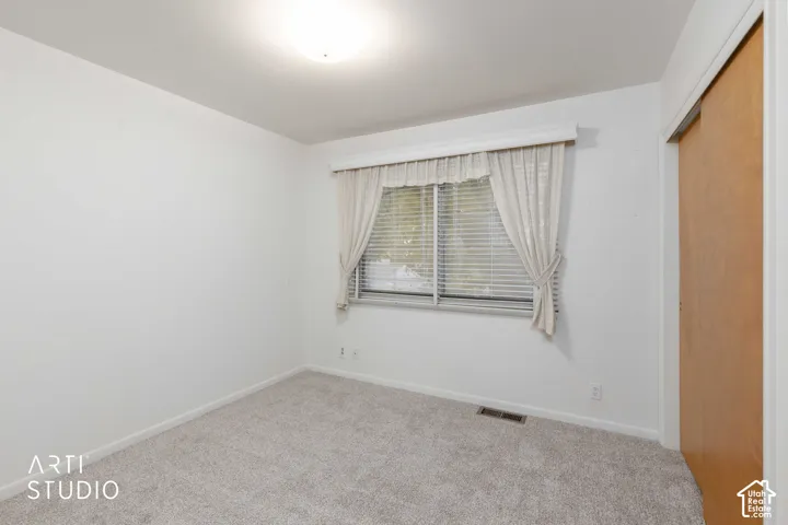 Neutral wall finishes, neutral carpeting, horizontal window blinds, and sliding wood-finish closet doors