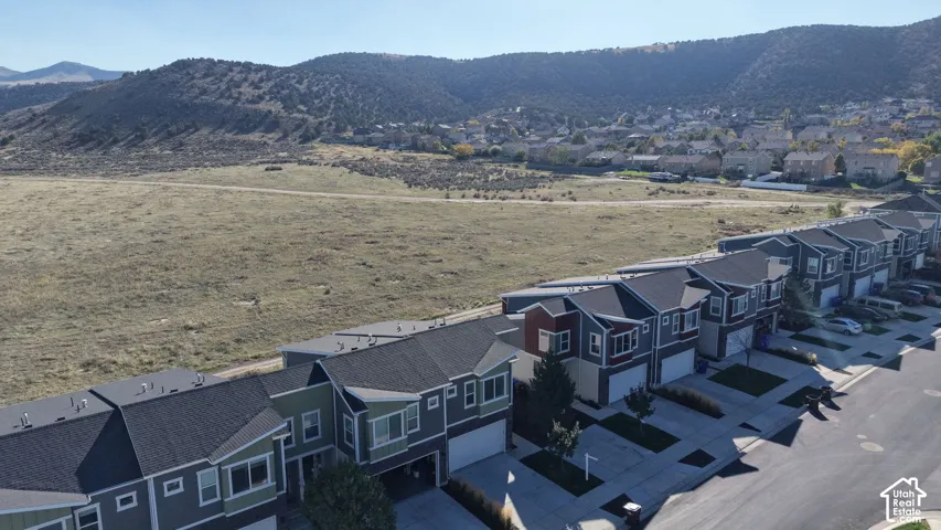Aerial perspective of multi-level residential structures featuring shingled rooflines, attached garages, and a mountainous backdrop