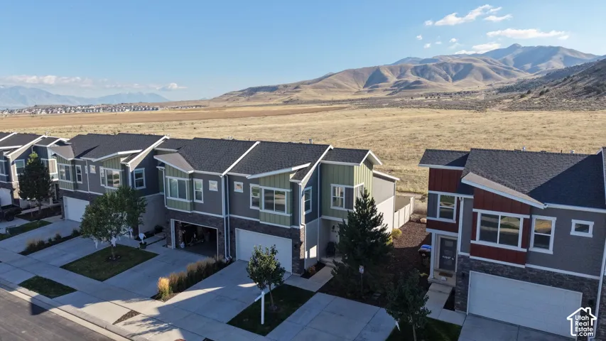 Multi-level townhome exteriors featuring varied roof pitches, stone veneer, and vertical siding, accompanied by mountain scenery