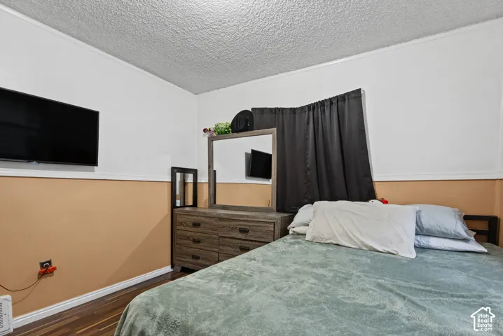 Room featuring two-tone wall finish with chair rail molding and dark wood-finish flooring