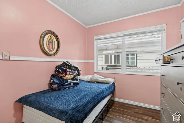 Room featuring wood-finish flooring, white chair rail molding, and a dual-pane horizontal sliding window