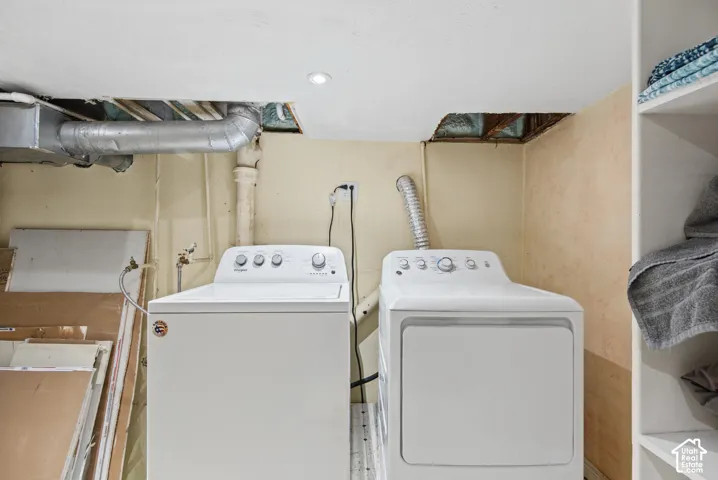 Laundry area featuring a top-load washer, front-load dryer, and integrated open shelving