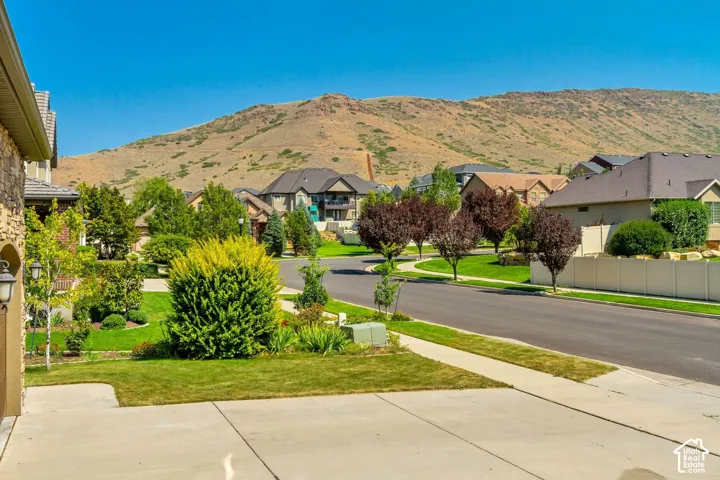 Exterior showing stone veneer detailing, concrete driveway, and mountain backdrop