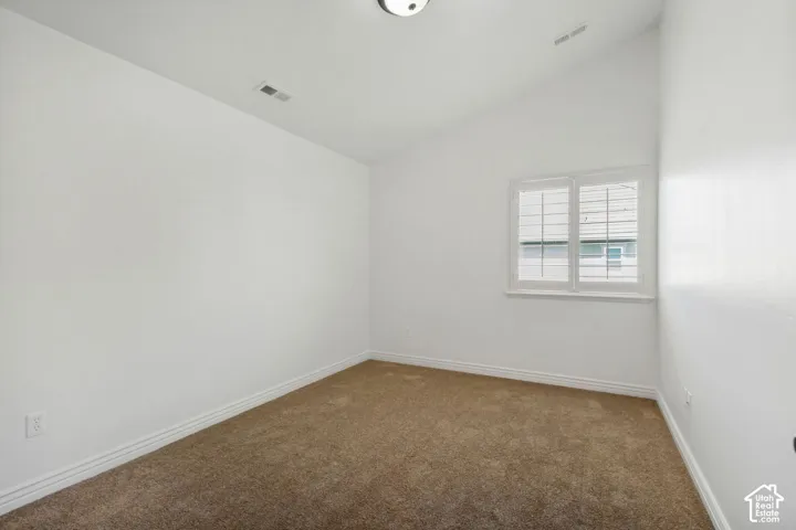 Vaulted ceilings, neutral carpeting, and plantation-style window shutters