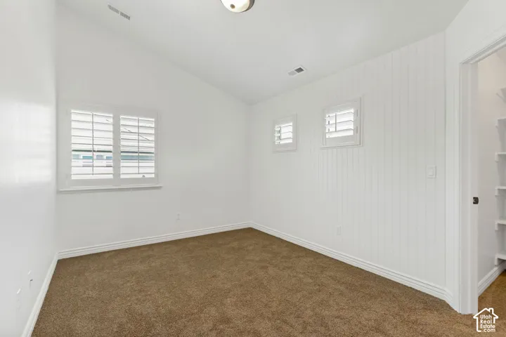 Vaulted ceilings, plank wall paneling, plantation shutters, and built-in closet shelving