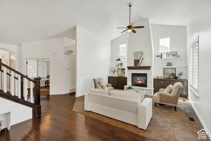 Vaulted ceilings, wood-finish flooring, floor-to-ceiling masonry fireplace with wood mantel, built-in cabinetry, and white plantation shutters