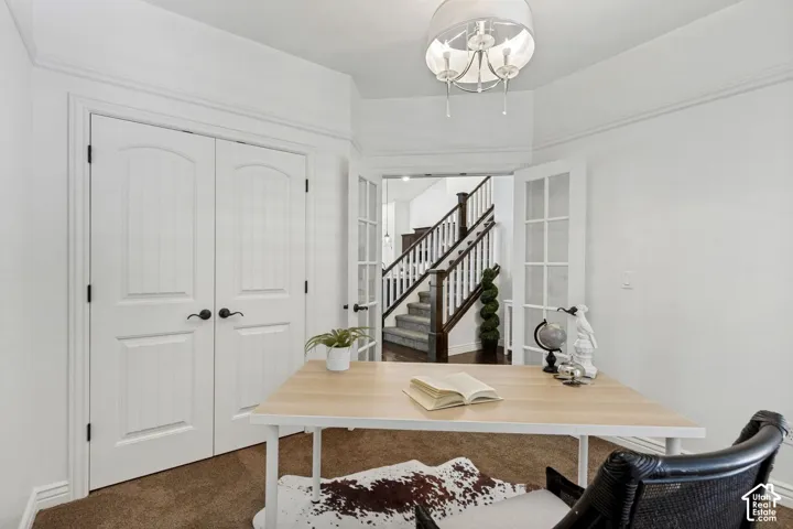 Room featuring double-panel interior doors, glass-paneled French doors, crown molding, and a multi-light drum chandelier