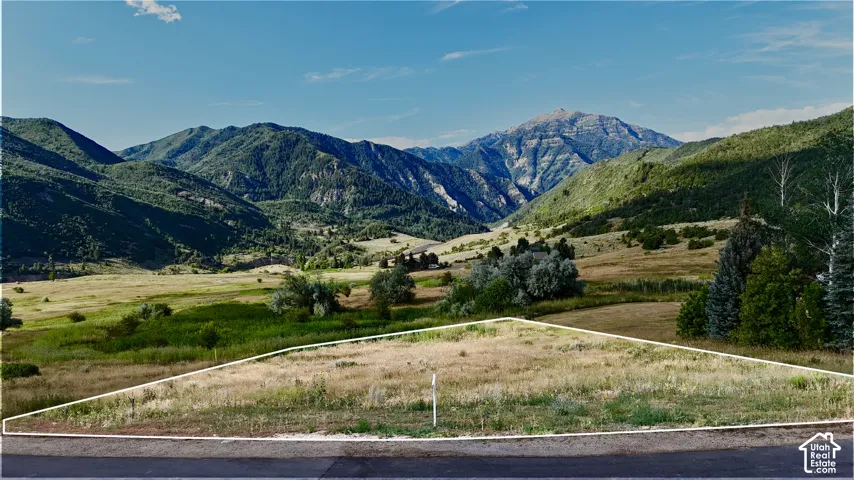 Vacant lot featuring a defined property boundary, natural terrain, and prominent mountain scenery