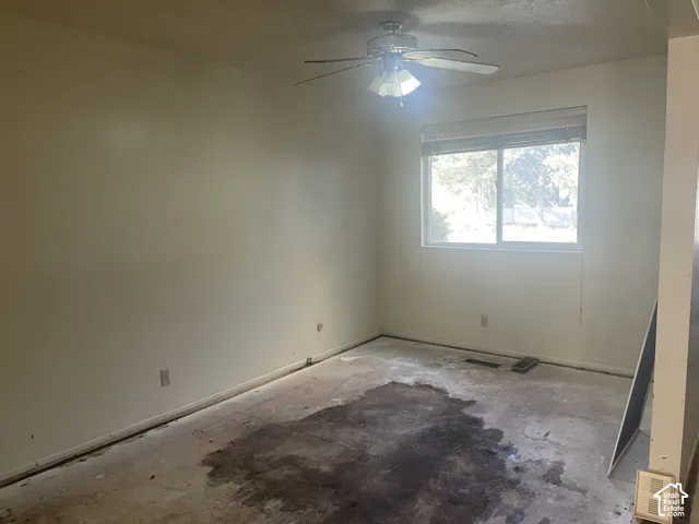 Interior room featuring a single-pane sliding window, ceiling fan with integrated light fixture, and horizontal blinds