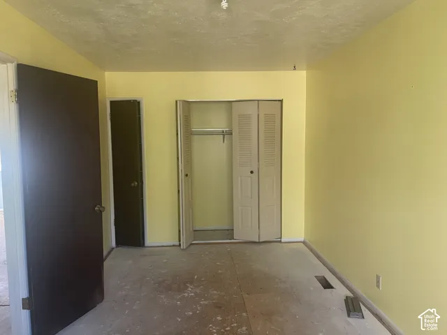 Interior room featuring a closet with bi-fold louvered doors, an additional door to an enclosed space, and a ceiling-mounted light fixture