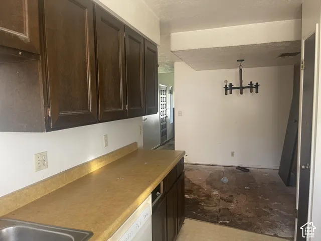 Kitchen featuring dark wood-finish cabinetry, solid-surface countertops, and a built-in multi-arm overhead light fixture