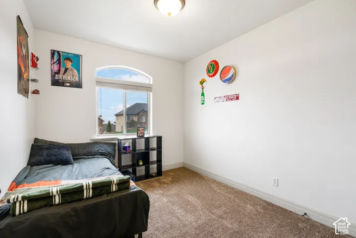 Room featuring arched window, neutral wall paint, carpeting, and flush-mount ceiling light fixture
