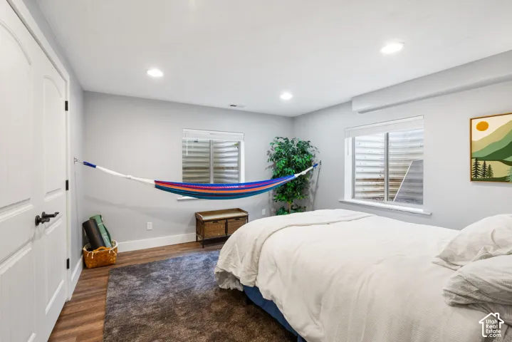 Neutral-toned interior featuring wood-finish flooring, recessed lighting, and dual egress windows with integrated window wells