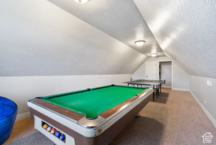 Finished interior space featuring vaulted ceilings, neutral-toned wall-to-wall carpeting, and multiple recessed light fixtures