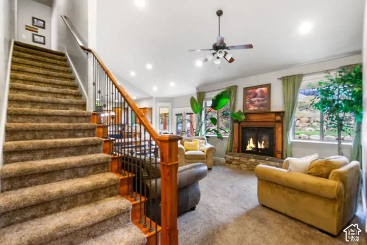 Fireplace featuring a stone hearth and wood mantel, metal spindle staircase railing, and recessed ceiling lighting