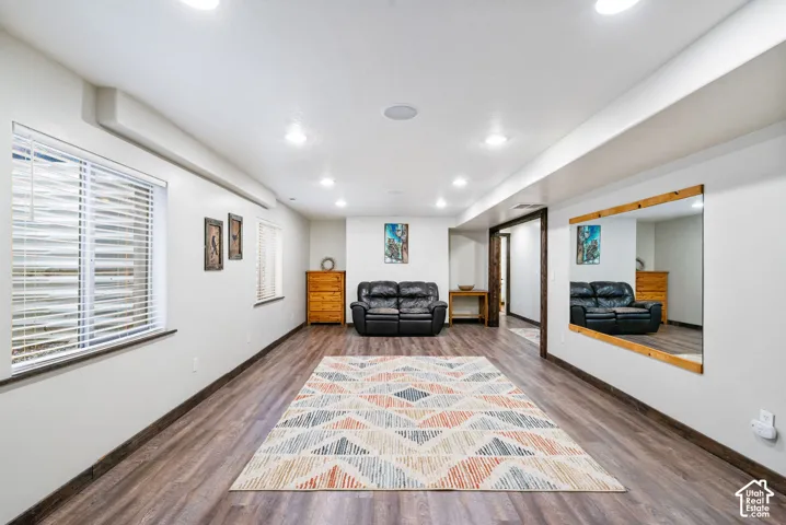 Recessed ceiling lighting, wood-finish flooring, and large wall-mounted mirror with a wood frame