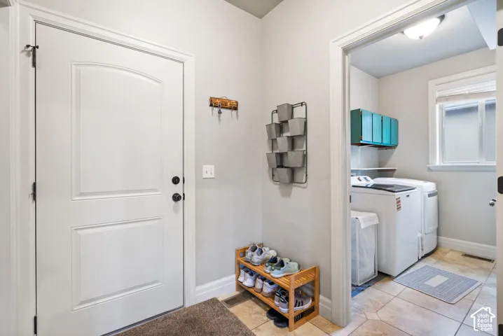 Entryway featuring a panelled door and neutral wall finish, tile flooring, and built-in wall-mounted cabinetry